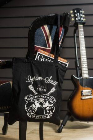 Gordon Smith tote bag with the iconic GS crossed guitars tattoo - portrait - hanging off chair - 1